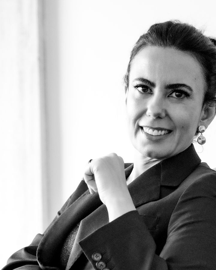 Monica Helena Moreira Pires sorrindo, sentada numa poltrona