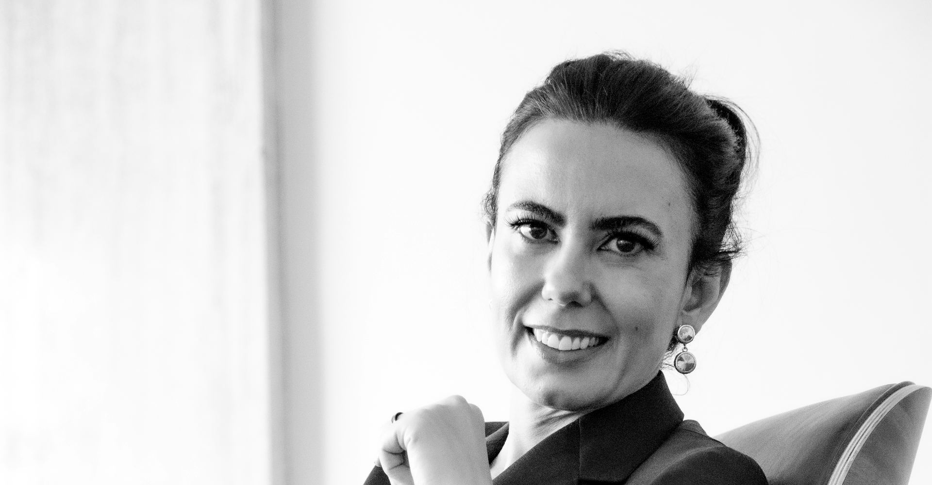 Monica Helena Moreira Pires, advogada, sorrindo, sentada numa poltrona